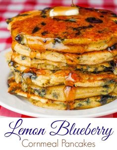 a stack of pancakes with syrup on top sitting on a plate next to a red and white checkered tablecloth