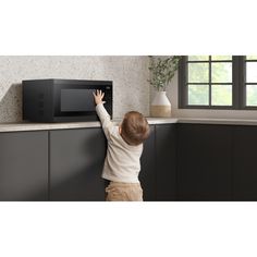 a small child reaching into a microwave oven