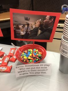 a table topped with candy and candies next to a sign that reads, kevin sometimes we play who can this mouth?