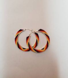 fire colours beaded hoop earrings. 1.5 in hoop 2 in diameter with beadwork. made with size 15 seed beads. Multicolor Small Hoop Jewelry With Spacer Beads, Multicolor Hoop Jewelry With Spacer Beads, Multicolor Hoop Beaded Earrings With Spacer Beads, Multicolor Beaded Hoop Earrings With Spacer Beads, Yellow Beaded Small Hoop Jewelry, Multicolor Beaded Small Hoop Jewelry, Handmade Beaded Bracelets For Gifts, Small Hoop Beaded Earrings With Tiny Beads For Festival, Orange Hoop Beaded Earrings As Gift