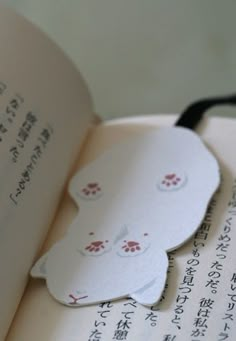 an open book with some paper cutouts on it's cover and writing in japanese