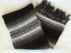 two black and white striped scarves laying on top of each other next to each other