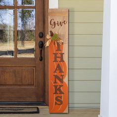 a wooden sign that says give thanks with a pumpkin on it in front of a door