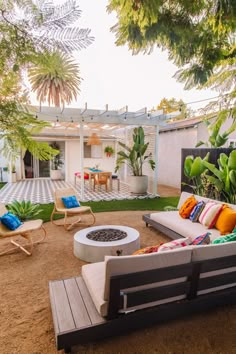 an outdoor living area with chairs, tables and fire pit in front of the house