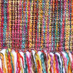 multicolored rug with fringes on the bottom and sides, close up photo