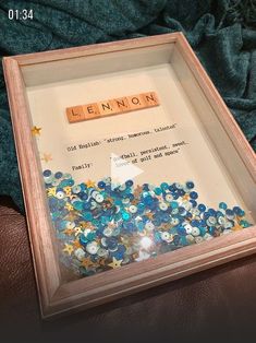 a wooden scrabble frame with letters spelling the word lenon and stars in it