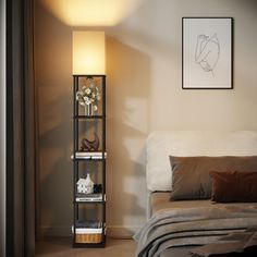 a bed sitting next to a lamp in a bedroom