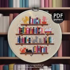 a cross stitch book shelf with books on it