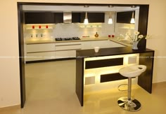 a modern kitchen with an island and bar stools in the center, lighted by recessed lighting