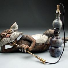 a cat figurine laying on its back next to an electric lamp with a cord