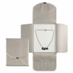 a white case with a necklace and matching pouch for the clasp to hold an item