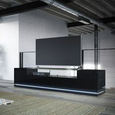 a flat screen tv sitting on top of a black entertainment center in a living room