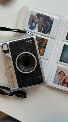 a camera sitting on top of a table next to pictures