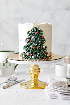 a white cake with a christmas tree decoration on it sitting on top of a table