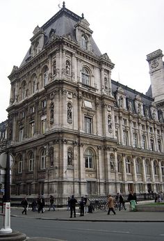 people are walking around in front of an old building