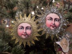 two sun and moon ornaments hanging from a christmas tree