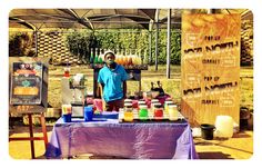 a man standing in front of a table filled with different types of drinks and condiments