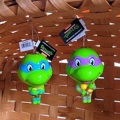 two plastic turtle ornaments are hanging from the ceiling in front of a wicker basket