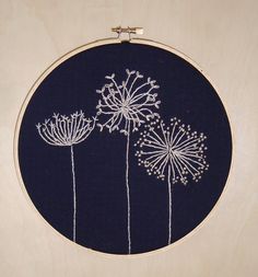 a embroidery project with dandelions on a blue background