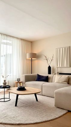 a living room filled with furniture and a white rug on top of a hard wood floor