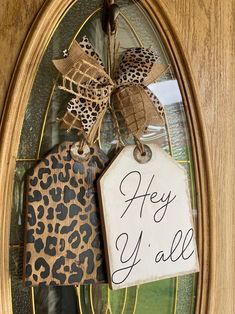 a sign that says hey y'all hanging on the front door with a leopard print bow