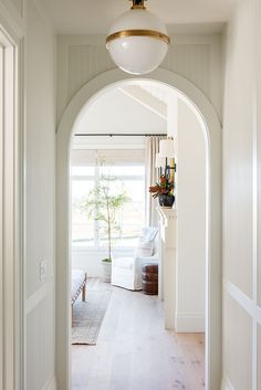 an archway leading to a living room with white furniture