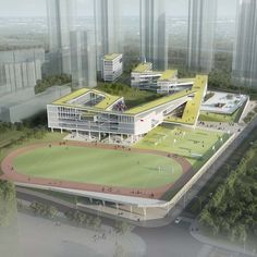 an aerial view of a soccer field with buildings in the background and trees around it