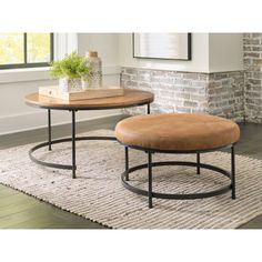 two coffee tables sitting on top of a rug in front of a brick wall and window