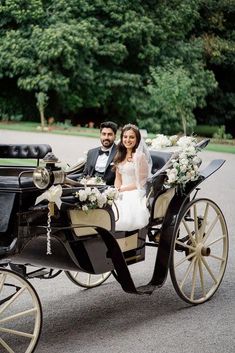 a bride and groom are riding in a horse drawn carriage