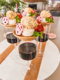 three wine glasses filled with desserts on top of a table