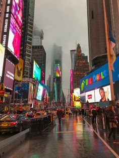 a city street filled with lots of traffic and tall buildings covered in neon colored signs