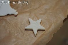 a white star shaped cookie sitting on top of a piece of parchment paper