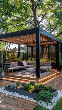 an outdoor living area with wooden decking and plants on the ground, surrounded by trees