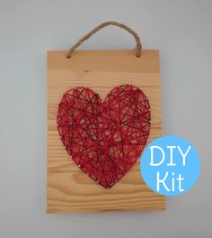 a string art heart is hanging on a wooden board with the words diy kit below it