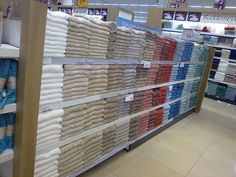 towels are stacked up on the shelves in a store, ready to be used as blankets