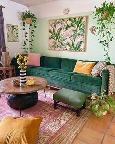 a living room filled with green couches and colorful pillows on top of a rug