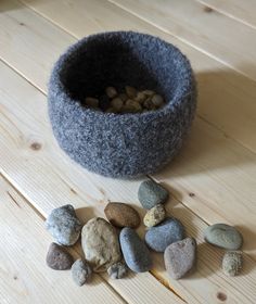 there is a bowl with rocks in it on the floor next to a cat bed