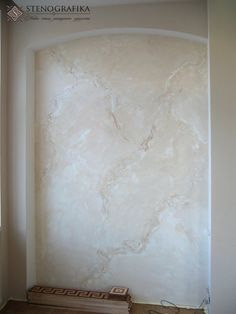 an empty room with white marble walls and flooring in the corner, along with a book shelf