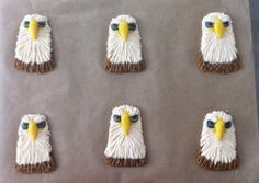 six decorated cookies in the shape of an eagle's head on a baking sheet