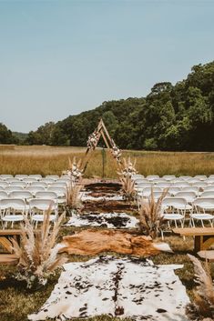 an outdoor ceremony set up with white chairs and snow covered rugs on the ground