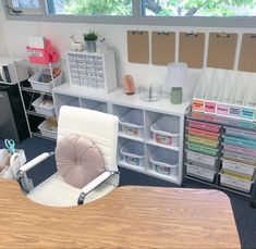 a chair sitting on top of a wooden table in front of a desk with lots of bins