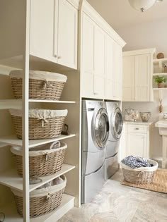 a washer and dryer sitting in a room next to some shelves with baskets on them