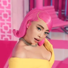 a woman with pink hair wearing a yellow dress in a pink and white bathroom area