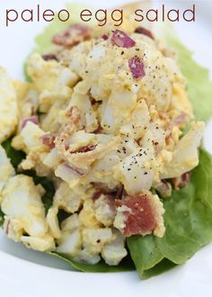 a salad with lettuce and other vegetables on a white plate that says paleo egg salad