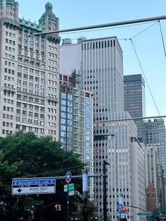 an intersection in the city with many tall buildings on either side and street lights above them