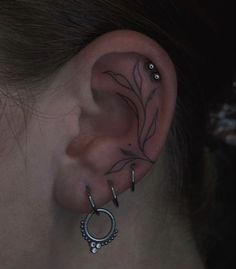 a woman's ear is adorned with piercings