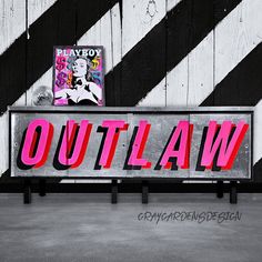 a sign that says out law on it in front of a wall with black and white stripes