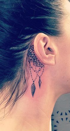 a woman with a tattoo on her neck and behind the ear is a small feather