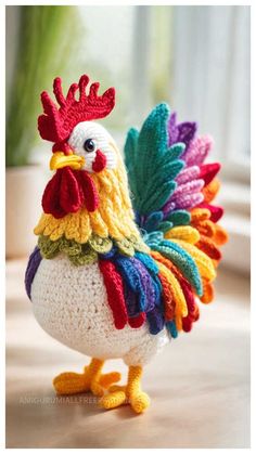 a crocheted chicken is standing on the table