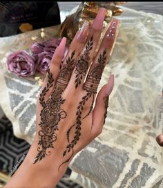 a woman's hand is decorated with hennap and flowers on it,